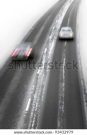 Two cars in blurred motion on winter highway