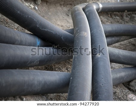 Heap of black plastic pipes at construction site