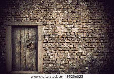 Ancient wooden door in wall built with natural rocks