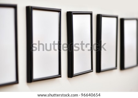 row of empty picture frames on wall