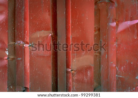 Close up of metal wall with scratched red paint