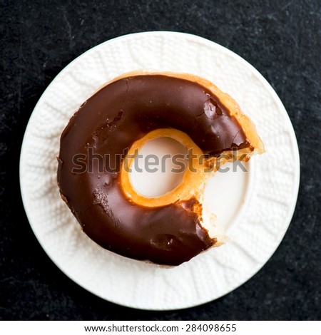 Glazed Donut with Bite Missing on white plate