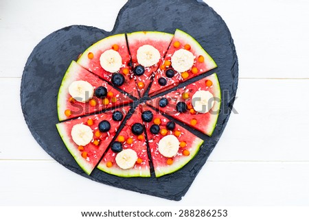 Vegan Snack from Watermelon, Fruits and Berries - blueberries, shredded coconut, bananas,  Seabuckthorn berries