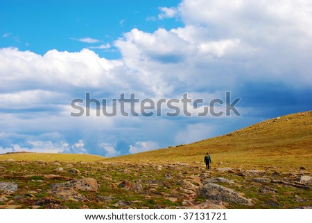A hiker walks through the tundra in the Rocky Mountains in Colorado