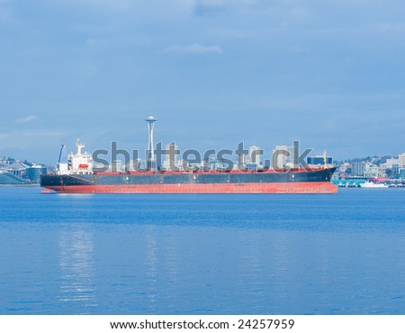 Empty cargo ship moored at Elliott Bay with Seattle skyline in background