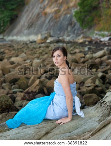 Young girl posing as water sprite on the rock