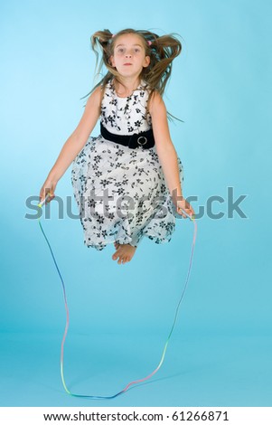Little girl with jumping rope in midair