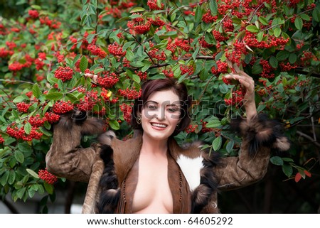 Woman in leather and furs reaching for winter berries