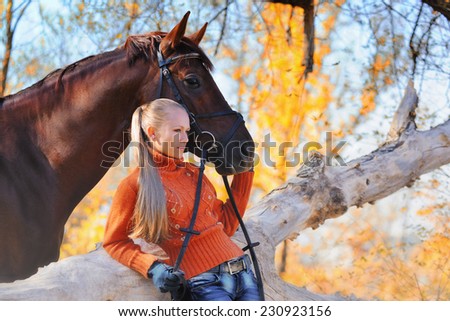 Beautiful girl with chestnut horse in autumn forest