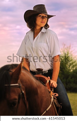 Beautiful cowgirl with her horse on sunset