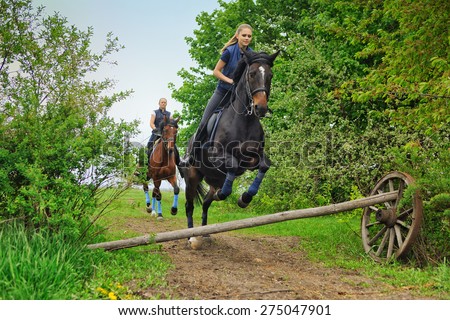 Two  girls riding horses  on countryside