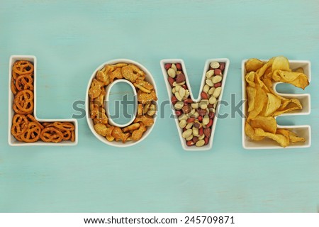 Love snacks in Love letter bowls on a distressed duck egg blue wooden background.