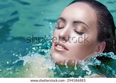 Wet woman face with water drop. Moisturizing in the sea