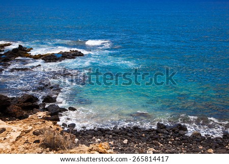 Lanai Hawaii.  A rock beach.  Shipwreck beach.  Blue water.  Black rocks.
