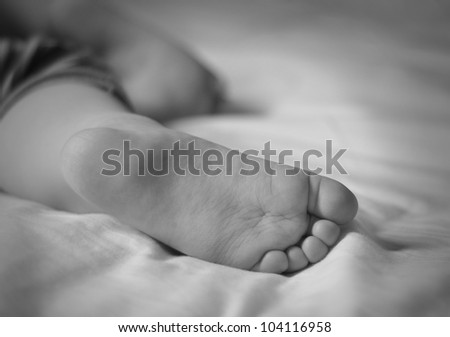 A closeup of a babies feet with toes in black and white. Use it for a sleep or time concept for children.