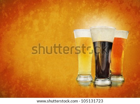 Three beer glasses have foam and are on a golden background with a rough texture. Use it for a Bar or celebration concept.