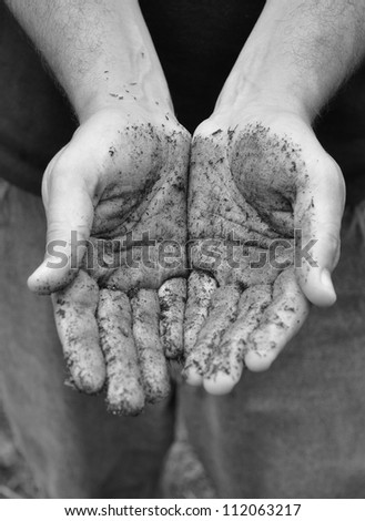 A closeup of a man\'s hands with dirt and soil. The dirty hands are empty and showing nothing.