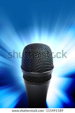An audio microphone is glowing on a blue background. Use it for a music or entertainment concept.