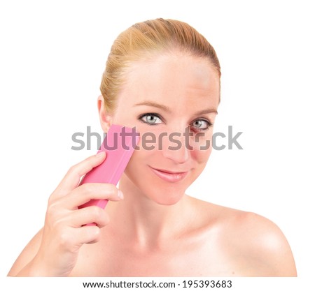 A woman is holding an eraser and removing wrinkles and blemishes on her face on an isolated white background for a youth concept.