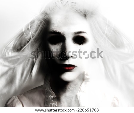 A scary evil woman with black eyes and red lips is death on a white background for a fear or Halloween concept.