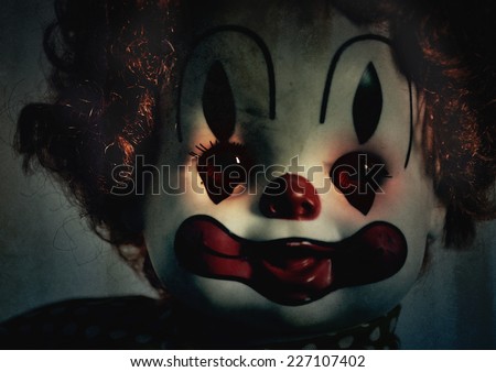 A closeup of a scary evil clown toy doll that could be possessed with evil. Use it for a halloween or fear concept.