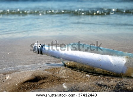 A glass bottle has a message inside and it has washed up on a sandy ocean, lake shore. Use it to represent help, survival or a hidden secret.