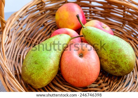 Still life composed of fruits and apples placed in a wicker baskets, lit by natural light