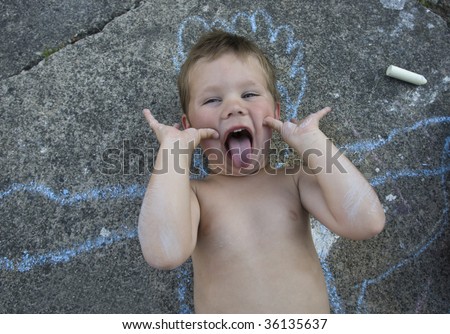 Boy on concrete with chalk outline makes a face.