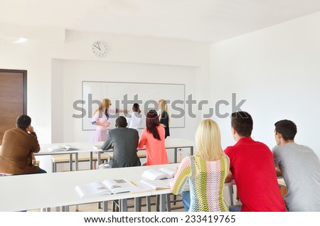 Professor examines a group of young students, black, white, Chinese and girls