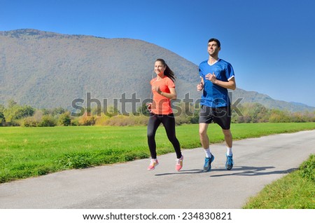 a group of young athletes running outside in the park in sunny weather