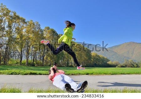 fitness, sport, friendship and lifestyle concept - smiling couple with earphones running outdoors