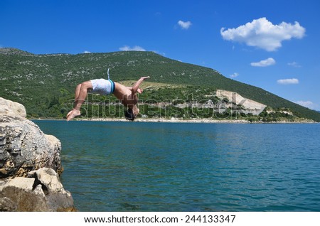 young man jumps into the sea, a beautiful summer day
