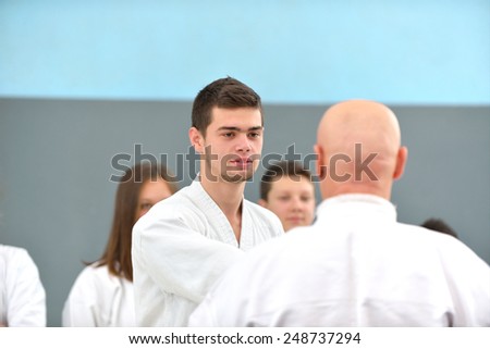 successful old karate master shows a group of young