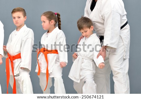 successful old karate master trains a group of young people karate