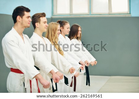 a group of young, beautiful and successful karate women and men posing with karate master
