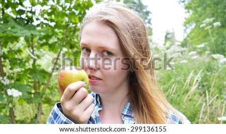 Woman eating apple in park