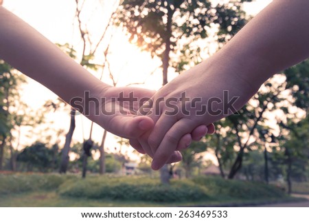 Couple holding hand in sunset, soft focus classic tone