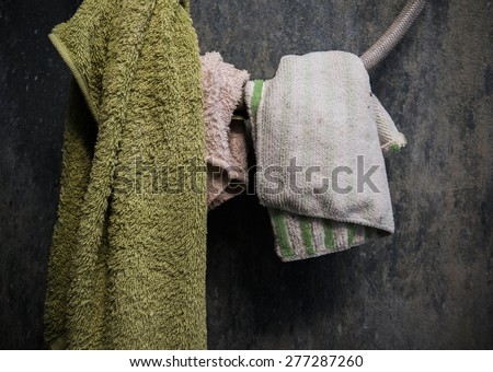 Hanging dirty towel and cotton on shower wire with dirty grunge concrete wall in toilet