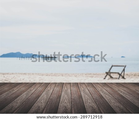 vintage tone, wooden terrace and out of focus beach with single chair