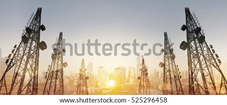 Silhouette, telecommunication towers with TV antennas and satellite dish in sunset, with double exposure city in sunrise background