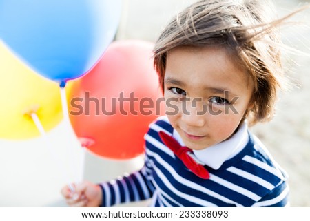 little boy walking with balloons