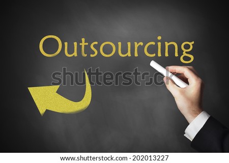 hand drawing outsourcing and arrow on black chalkboard