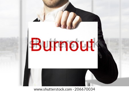 businessman in black suit holding sign burnout
