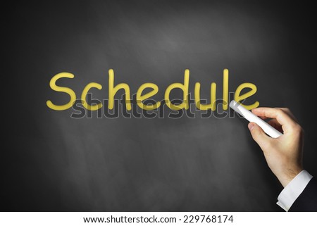 hand writing schedule on black chalkboard school plan