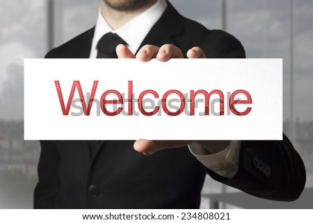 businessman in office holding sign welcome