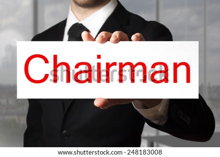 businessman in black suit holding sign chairman