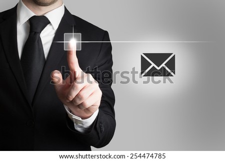 businessman in office pushing touchscreen button mail symbol