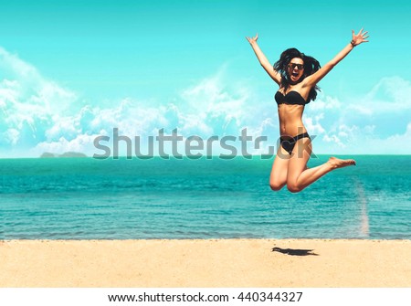 Attractive Girl in Bikini Jumping on the Beach Having Fun, Summer vacation holiday Lifestyle. Happy women jumping freedom on white sand.