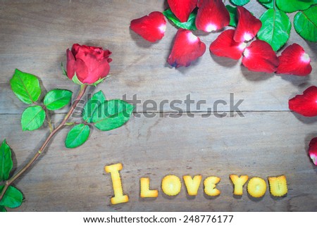 Happy Valentine's Day red roses on dark recycled wood background with word I Love You dessert
