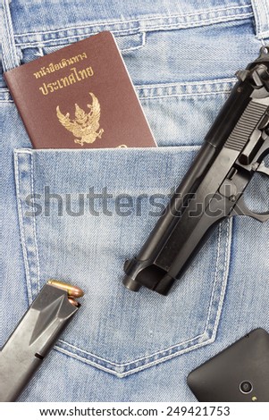 Thai passport phone and gun in jeans pocket